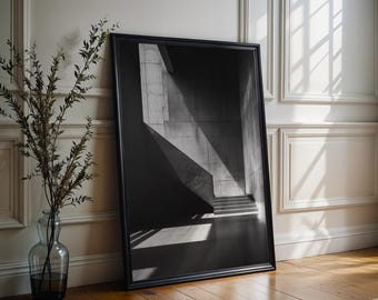 May include: A black framed rectangular wall art print featuring a high-contrast black and white architectural photograph of concrete stairs and geometric shadows. The artwork is displayed in a simple black frame with a clean, sharp aesthetic.