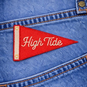 May include: A white ceramic mug with a black handle and the text "But First, Coffee" in a black, bold font. The mug is sitting on a wooden surface.