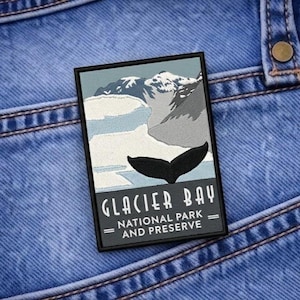 May include: Embroidered patch featuring a scenic view of Glacier Bay National Park and Preserve. The design includes a whale tail, mountains, and the text "Glacier Bay National Park and Preserve" in white lettering on a black background.
