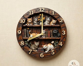 May include: A round wall clock with a dark brown wood-textured frame and gold numbers. The clock face features shelves with miniature cats, stacks of books, and a small vase of yellow flowers. Two gold clock hands are positioned in the center.