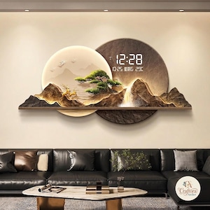 May include: A wall-mounted digital clock featuring a layered circular design with a relief landscape of mountains, a pine tree, and deer. The display shows the time 12:28, the date 10-25, and a temperature of 29C with Chinese characters for the day.