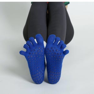 Puede incluir: Un par de calcetines azules con dedos y agarres antideslizantes en las suelas. Los calcetines tienen compartimentos individuales para cada dedo del pie. Diseñados para yoga, pilates o ejercicio. Fabricados con un material suave y transpirable.