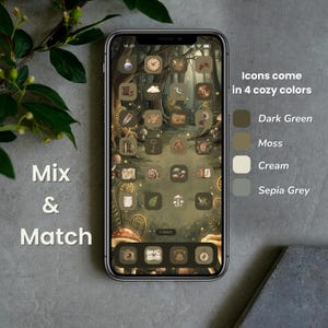A smartphone screen shows a forest-themed app icon set in dark green, moss, cream, and sepia grey. The screen displays a forest scene with mushrooms and trees. Text on the screen says "Mix & Match" and "Icons come in 4 cozy colours."
