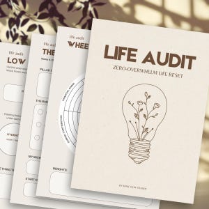 Può includere: Una pila di diari di carta beige con le parole "LIFE AUDIT" e "ZERO-OVERWHELM LIFE RESET" stampate sulla copertina. La copertina presenta una grafica a forma di lampadina con fiori all'interno. Altri diari hanno testo come "LOW" e "WHEE".
