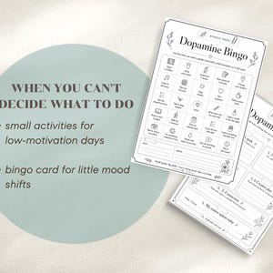 May include: Two white paper sheets with the text "Dopamine Bingo" and "Dopamine Menu" are displayed. The bingo card features a grid of small activities, while the menu lists options for mood shifts. The background is a light green circle with text.