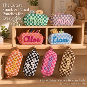 May include: Eight rectangular zippered pouches with a checkered pattern in various colours, each featuring a custom 3D name patch. The pouches measure 19 cm x 7.5 cm x 9.5 cm and are designed to hold snacks or pencils, showcasing names like Mao, Ava, Chloe, Liam, Ryan, Lee, Luna, and Noah.
