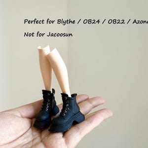 May include: A pair of miniature doll legs in a light skin tone wearing black lace-up boots with thick soles and side zippers. The text in the image reads: Perfect for Blythe / OB24 / OB22 / Azone. Not for Jacoosun. These doll accessories are black.