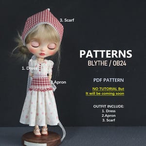 May include: A doll wearing a white dress with a red and white checkered apron and scarf. The doll has blonde hair and is standing on a wooden base. The image includes the text "PATTERNS BLYTHE/OB24" and "PDF PATTERN".