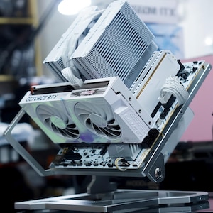 May include: A white ceramic mug with a black handle and the text "But First, Coffee" in a bold, black font. The mug is set against a blurred background, suggesting a cozy setting.