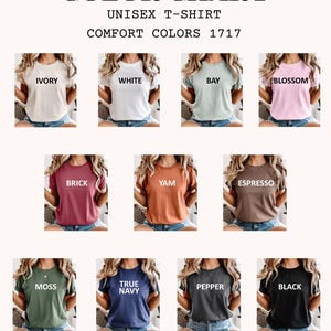 K&ouml;nnte beinhalten: Farbkarte f&uuml;r Unisex-T-Shirts mit Comfort Colors. Die Karte zeigt T-Shirts in den Farben Ivory, Wei&szlig;, Bay, Blossom, Brick, Yam, Espresso, Moss, True Navy, Pepper und Schwarz. Der Text "COLOR CHART" steht oben.
