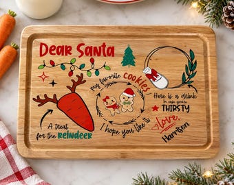 May include: A rectangular wooden serving board featuring the text Dear Santa, a carrot with reindeer antlers, a gingerbread couple, and a drink illustration. The board includes the phrases A treat for the reindeer, my favorite cookies, I hope you like it, and Here is a drink in case you're THIRSTY, signed by Harrison.