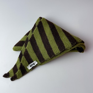 May include: A triangular knit scarf featuring alternating dark brown and olive green stripes. The fabric has a textured, soft appearance. A small white rectangular fabric tag with the black text SOMI is attached to the edge of the scarf.
