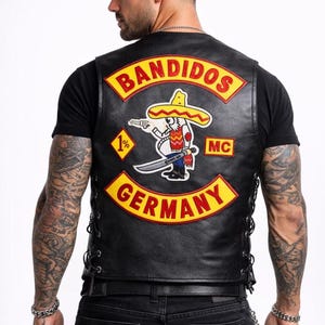 May include: Black leather vest with the word "BANDIDOS" in yellow lettering. The vest features a patch with a cartoon character wearing a sombrero, holding a gun and a knife, with the text "GERMANY" below.