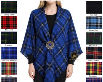 May include: A blue tartan shawl with black and white accents, secured with a decorative brooch. The shawl has a fringed edge and is displayed with various tartan patterns. Text reads "Available in 60+ Tartans."
