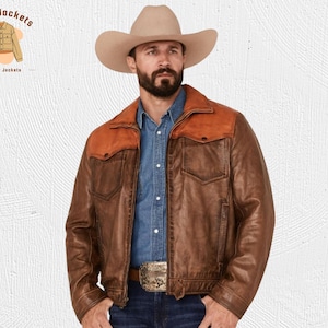 May include: Brown leather jacket with a contrasting orange yoke and two front pockets. The jacket has a button closure and a belt buckle. The logo "Kraft Jackets Leather Jackets" is in the upper left corner.