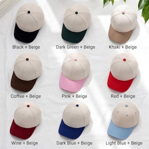 May include: A selection of nine beige baseball caps, each with a different coloured peak and button. The peak colours are black, dark green, khaki, coffee, pink, red, wine, dark blue, and light blue. Text labels identify each colour combination.