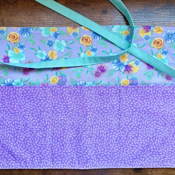 Delantal utilitario morado con estampado floral y 3 bolsillos