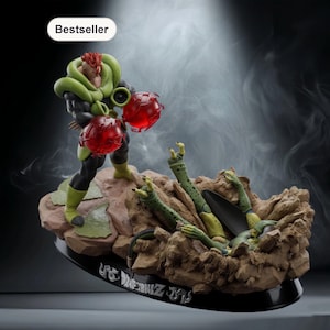 Könnte beinhalten: Detaillierte Figur eines Dragon Ball Z-Charakters, mit einer grün-schwarzen Figur, die zwei rote Energiesphären hält. Die Figur steht über einem besiegten Gegner auf einem felsigen Sockel. Der Sockel trägt den Text "Dragonball Z".
