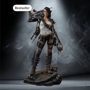 Könnte beinhalten: Detaillierte Figur einer Kriegerin in zerrissener Kleidung und taktischer Ausrüstung, die eine Waffe hält. Die Figur steht auf einem felsigen Sockel mit Totenköpfen und trägt eine Lederjacke und Kampfstiefel. Das Wort "Bestseller" befindet sich in einem weißen Oval.