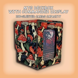 Könnte beinhalten: Eine quadratische MTG-Deckbox mit Commander-Sichtfenster, verziert mit einem Muster aus roten Pilzen und dunklen Beeren auf schwarzem Grund. Der Text lautet MTG DECKBOX WITH COMMANDER DISPLAY und 100+ SLEEVED CARDS CAPACITY. Eine Karte ist im vorderen Schlitz sichtbar.