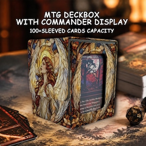 May include: A rectangular deck box for trading cards featuring a stained glass style illustration of an angel with long red hair and wings. The front includes a clear display window showing a game card. Text reads MTG DECKBOX WITH COMMANDER DISPLAY 100+SLEEVED CARDS CAPACITY.