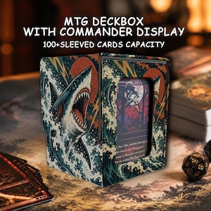 Op de afbeelding: Een rechthoekige MTG-deckbox met een displayvenster, voorzien van een afbeelding van een haai in golven en een rode zon. De tekst luidt MTG DECKBOX WITH COMMANDER DISPLAY en 100+SLEEVED CARDS CAPACITY. Geschikt voor meer dan 100 kaarten in hoesjes.