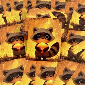 May include: A stack of rectangular art prints featuring a cartoon raccoon with large eyes holding a glowing yellow mushroom. The background is a warm, golden-toned forest scene with soft light particles, creating a bright and luminous atmosphere.