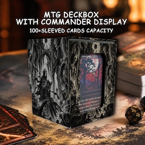 Op de afbeelding: Een zwart-witte MTG-deckbox met commander-display en een capaciteit voor 100+ gesleevde kaarten. De doos toont een duistere, gotische illustratie van een figuur met een kap in een bos. Een enkele speelkaart is zichtbaar in het voorste venster.