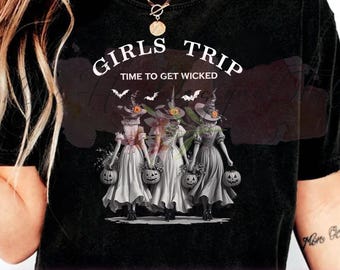 May include: Black t-shirt with the words "GIRLS TRIP TIME TO GET WICKED" in white. The shirt features a graphic of three witches holding pumpkin-shaped baskets. Bats are flying above the witches.
