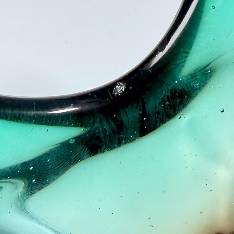 Vintage Czech art glass bowl in green and amber tones with sculptural organic shape and dramatic light reflections.