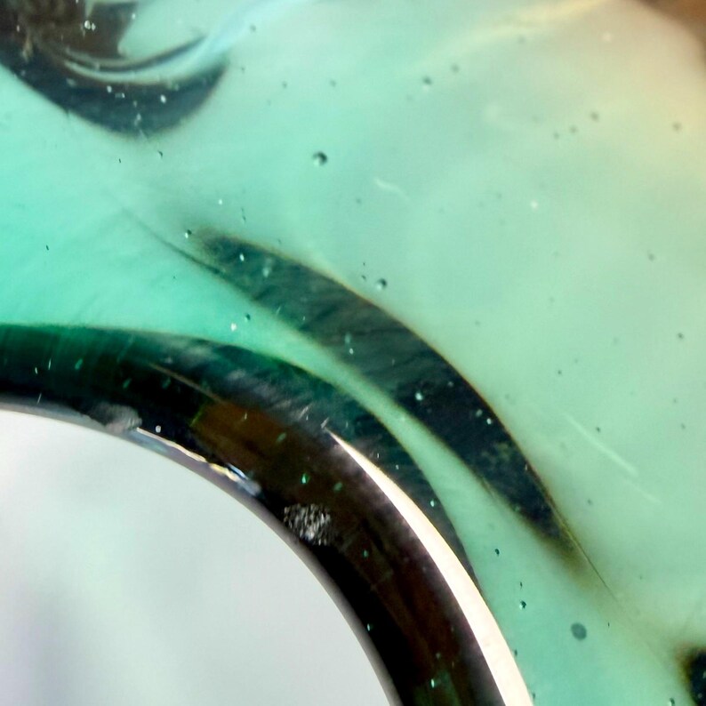 Vintage Czech art glass bowl in green and amber tones with sculptural organic shape and dramatic light reflections.
