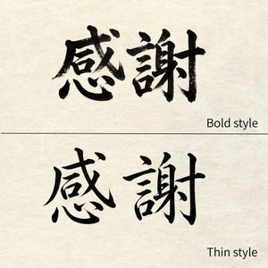 以下が含まれることがあります： 2つの日本語の書道例で、それぞれ黒インクで「感謝」という言葉が書かれています。上の例は太字スタイル、下の例は細字スタイルです。どちらもクリーム色の背景にあります。