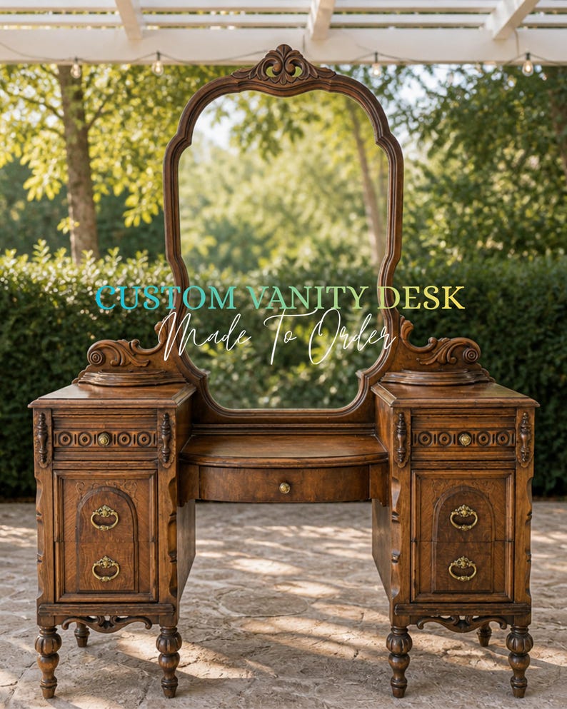 May include: A custom-made wooden vanity desk with an oval mirror. The desk has two side cabinets with drawers and ornate brass handles. The text "CUSTOM VANITY DESK Made To Order" is displayed on the image. The desk is made of dark wood.
