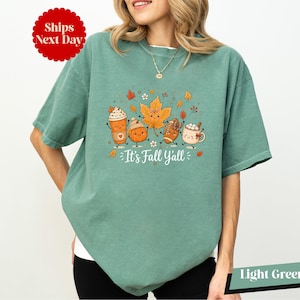 A woman wearing a green t-shirt with a graphic design of cartoon characters and text.