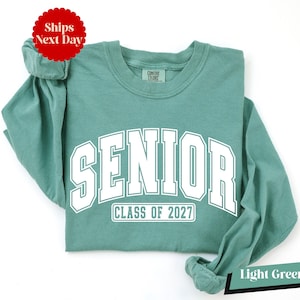 A light green long-sleeved t-shirt with the text "SENIOR CLASS OF 2027" printed on it.