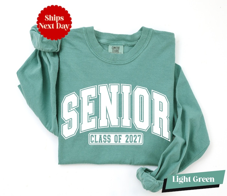 A light green long-sleeved t-shirt with the text "SENIOR CLASS OF 2027" printed on it.