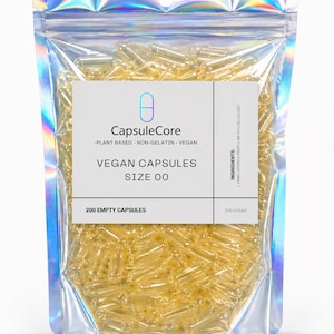 May include: A clear, holographic bag filled with yellow vegan capsules. The bag has a white label with the text "CapsuleCore" and "VEGAN CAPSULES SIZE 00". The label also states "200 EMPTY CAPSULES" and "200 COUNT".