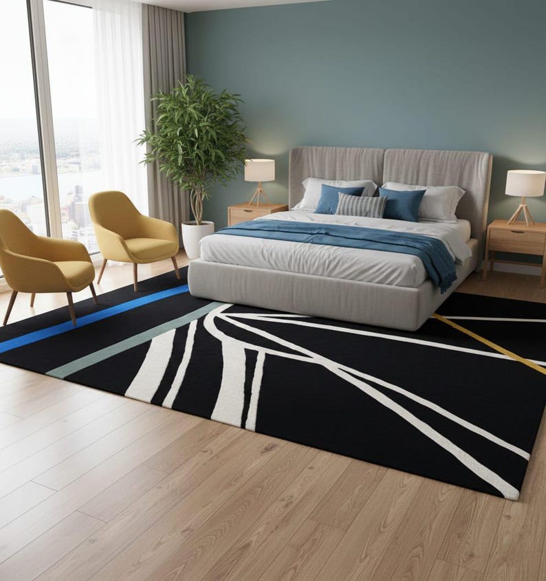 May include: A black rectangular area rug with a geometric design in white, blue, and yellow. The rug is in a bedroom with a bed, two yellow chairs, and a large window. The rug measures approximately 8 feet by 10 feet.