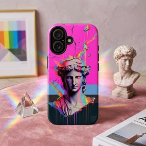 May include: A pink phone case featuring a digital art design of a classical bust with a cracked effect and rainbow accents. The case has a black camera module and a dark teal bottom.
