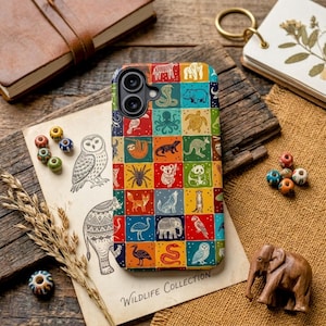 May include: A colorful phone case featuring a grid of animal illustrations, including a sloth, fox, and panda. The case is set on a wooden surface with a vintage paper and decorative beads. The words "Wildlife Collection" are printed on the paper.