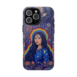 May include: A smartphone case featuring a dark blue background with a central figure with long dark hair and a third eye on the forehead. The figure is surrounded by a rainbow arch, floral vines, stars, a crescent moon, and a planet in space.