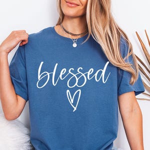 May include: A white ceramic mug with a black handle and the text "But First, Coffee" in a black, handwritten-style font. The mug is on a white surface.