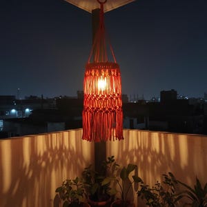 Handmade red macrame hanging lampshade with warm ambient light, boho cotton pendant lamp shade for cozy living room and bedroom decor