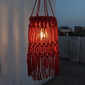 Handmade red macrame hanging lampshade with warm ambient light, boho cotton pendant lamp shade for cozy living room and bedroom decor