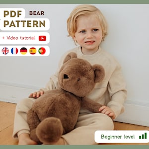May include: A brown teddy bear is held by a child. The image includes text that reads "PDF BEAR PATTERN" and "+ Video tutorial". The text also includes the words "Beginner level".