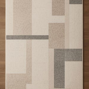 May include: Rectangular area rug with a geometric design in shades of beige, tan, and gray. The rug features a pattern of overlapping rectangles and lines. The text "AresRugDesign" is visible in the bottom right corner.