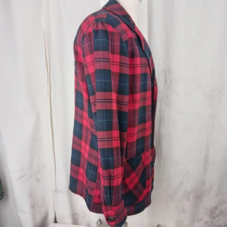 May include: A red, black, and navy plaid blazer. The blazer has a classic design with a notched lapel, long sleeves, and two front pockets. The plaid pattern is a bold and eye-catching design.