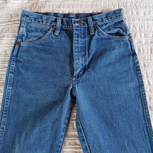 May include: A pair of blue denim jeans with a classic five-pocket style. The jeans have a straight leg and a high waist.