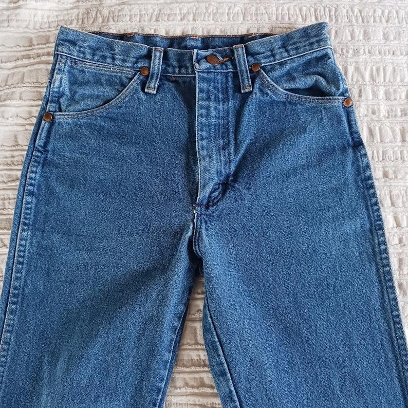May include: A pair of blue denim jeans with a classic five-pocket style. The jeans have a straight leg and a high waist.