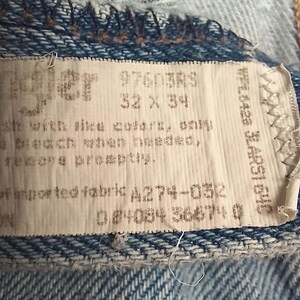 Puede incluir: Una etiqueta blanca con texto negro que dice "#760383 32 x 34" y "of imported fabric A274-0512 04034 36471 0".